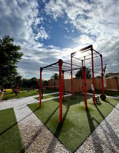 a playground with red poles on the grass at La Famiglia in Pollena Trocchia
