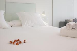 a white bed with towels and donuts on it at Pensión T5 Donostia Suites in San Sebastián