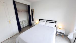 1 dormitorio blanco con 1 cama blanca y 2 lámparas en Sunny Mercury - Room in Apartment, en Cannes