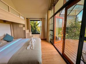 1 dormitorio con 1 cama y puerta de cristal grande en Nana Field Cabin 3, en Ban Phra Fang