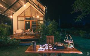 una mesa de madera frente a una casa por la noche en Nana Field Cabin 3, en Ban Phra Fang