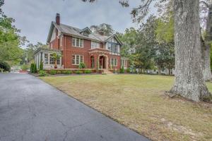 una gran casa de ladrillo rojo con un árbol en Family Laurinburg Home with Private Yard and BBQ, en Laurinburg