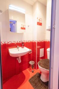 a red bathroom with a sink and a toilet at Cozy Apart TOP Center AUBG Free Garage Park in Blagoevgrad