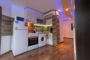 a kitchen with a white refrigerator and a dishwasher at Cozy Apart TOP Center AUBG Free Garage Park in Blagoevgrad