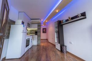 a kitchen with a white refrigerator in a room at Cozy Apart TOP Center AUBG Free Garage Park in Blagoevgrad
