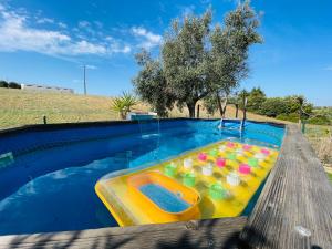 a swimming pool with a inflatable toy in it at Glamping Turquesa, feel and relax in a wood house in Corredoura
