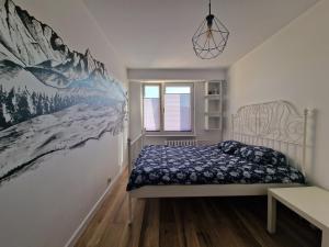 um quarto com uma cama e um quadro na parede em Apartament na wynajem em Nowy Targ