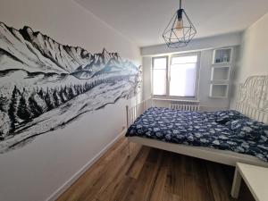 a bedroom with a snowy mountain mural on the wall at Apartament na wynajem in Nowy Targ