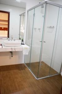 La salle de bains est pourvue d'une douche et d'un lavabo. dans l'établissement Pousada O Garimpo., à Embu