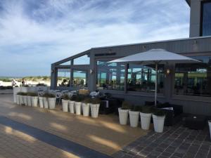 a row of potted plants sitting outside of a restaurant at Sleep at Sea in Nieuwpoort