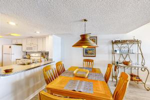a kitchen and dining room with a wooden table and chairs at B175 Amelia Surf and Racquet in Fernandina Beach