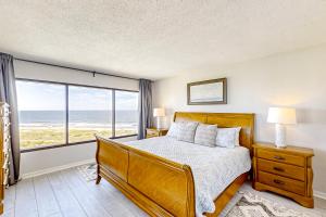 a bedroom with a bed and a view of the ocean at B175 Amelia Surf and Racquet in Fernandina Beach