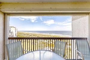 a table and chairs on a balcony with a view of the beach at B175 Amelia Surf and Racquet in Fernandina Beach