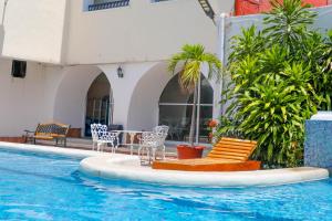 una piscina con sillas y un complejo en Hotel Maria de Lourdes, en Cancún