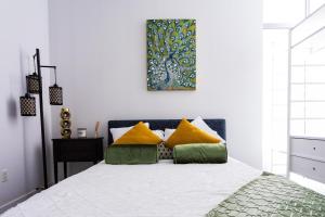 - une chambre dotée d'un lit avec des oreillers jaunes et verts dans l'établissement 1- Bdr Condo w Patio Close to the beach, à Long Beach