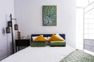 a bedroom with a bed with yellow and green pillows at 1- Bdr Condo w Patio Close to the beach in Long Beach