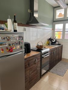 eine Küche mit einem Edelstahl-Kühlschrank mit Magneten in der Unterkunft Ponta Mina Room in São Tomé
