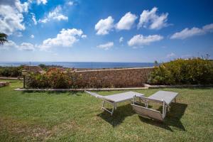 a white bench sitting on the grass in a yard at Dammuso Ignazio in Lampedusa