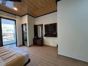 a bedroom with a bed and a flat screen tv at Hotel 7 Heavens in Mussoorie