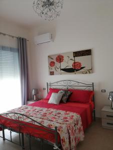 a bedroom with a red bed with a red comforter at Onde Salentine Deluxe in Casalabate