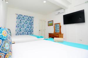 a bedroom with a bed and a tv on a wall at Hotel Maria de Lourdes in Cancún