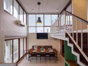 a dining room with a table and chairs and stairs at Bedtime storeys near ICON SIAM in Bangkok