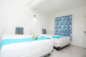 a bedroom with two beds and a couch at Hotel Maria de Lourdes in Cancún +21 photos