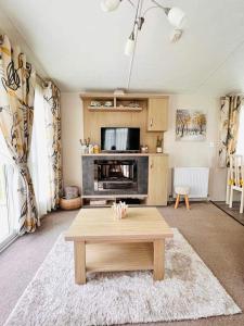 a living room with a coffee table and a tv at Bude 13 in Cubert