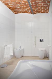 a white bathroom with a tub and a toilet at Casale Gioia in San Marzano Oliveto