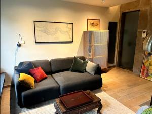 a living room with a couch with colorful pillows at L'atique by Agelandkaai be with Parking in Ghent +94 photos