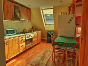 a kitchen with wooden cabinets and a table and a refrigerator at U WOJTUSIA in Czarny Dunajec