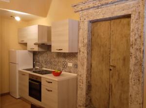 a small kitchen with white cabinets and a door at Le Dimore di Lucrezia :La Loggia in Nepi