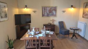 a dining room with a table and a television at Le Dimore di Lucrezia :La Loggia in Nepi