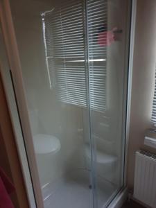 a shower with a glass door in a bathroom at Swift Burgundy in Prestatyn
