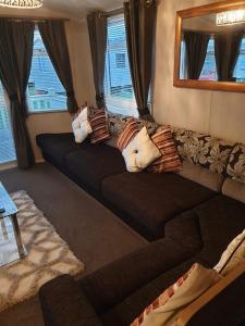 a living room with a couch with pillows on it at Swift Burgundy in Prestatyn +2 photos