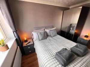 a small bedroom with a bed with towels on it at CONTRACTORS OR FAMILY HOUSE - M1 Nottingham - IKEA RETAIL PARK - CATKIN DRIVE - 2 Bed Home with Driveway, private garden, sleeps 4 - TV'S in all rooms 