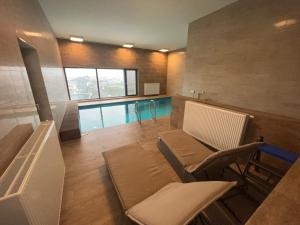 sala de estar con piscina, mesa y sillas en AZ Tower Apartment en Brno