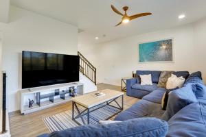 a living room with a blue couch and a tv at Rooftop Patio, Skyline Views Phoenix Townhome! in Phoenix