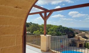 a balcony with a view of a swimming pool at Tas-Suplu Farmhouse in San Lawrenz