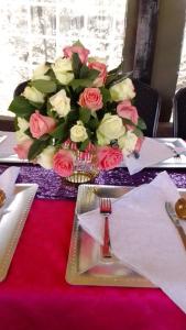a table with a vase of roses on top at Brownies Deluxe in Nakuru