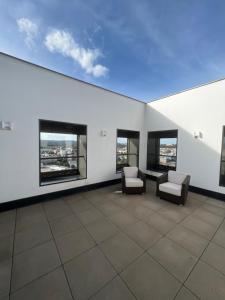 ブルノにあるAZ Tower Apartmentの椅子2脚と窓が備わる広々とした空の部屋です。