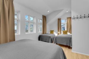 ein weißes Schlafzimmer mit 2 Betten und Fenstern in der Unterkunft Capital Luxury Apartments in Reykjavík