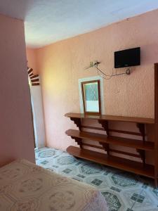 Cette chambre comprend un lit et une télévision murale. dans l'établissement Hotel Villa Luz, à Puerto Escondido