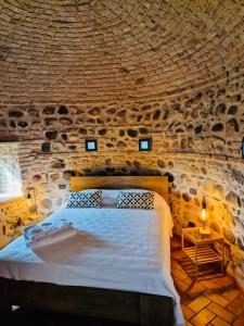 ein Schlafzimmer mit einem großen Bett in einer Steinmauer in der Unterkunft Vittoria alla Torre in Pozzolengo