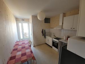a small kitchen with white cabinets and a table in it at Appartement centre-ville de Bergerac 4 personnes in Bergerac
