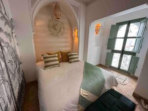 ein Schlafzimmer mit einem großen Bett mit Kissen darauf in der Unterkunft Riad ABADA Medina Marrakech (Sidi Mimoun) in Marrakesch