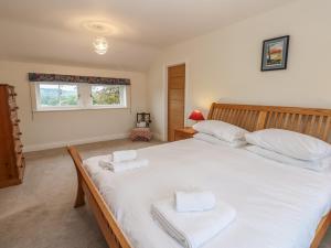 a bedroom with a large white bed with two towels at Larch House in Penrith