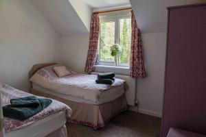 a small bedroom with two beds and a window at Bench Tor Apartment in Plymouth