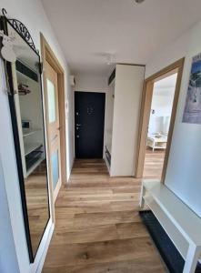 a hallway with a mirror and a wooden floor at Apartament na wynajem in Nowy Targ