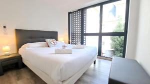 um quarto com uma grande cama branca e uma grande janela em Maison d'architecte centre Tours jardin, climatisation, parking 5 p em Tours